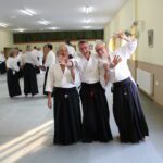 Three students, aware of the camera, waving and laughing.