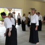 One student off-balances her attacker, whilst another watches