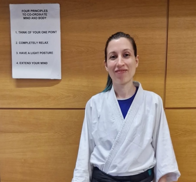 Photo of a studen standing in front of a sign